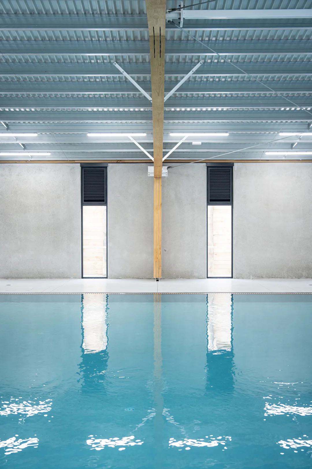 Symmetrical view of central timber post reflected in the pool